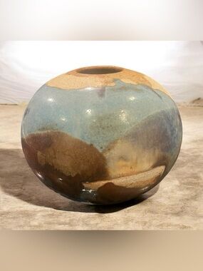 Spherical studio art pottery vase with a raku-style drip glaze.